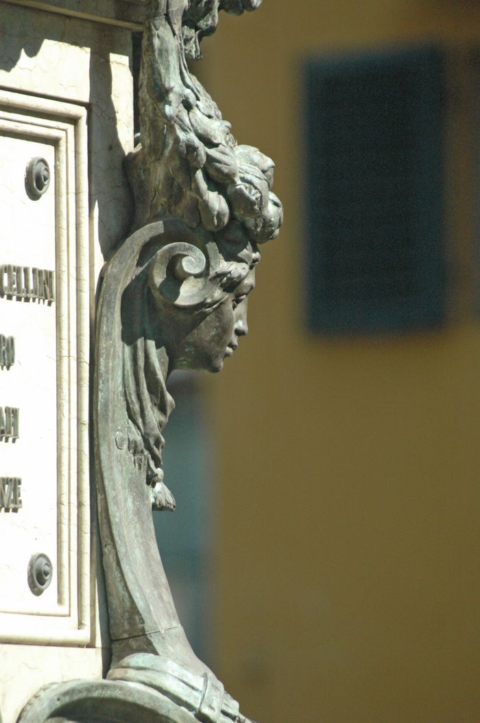 Close-up of an ornate metal sculpture detail illuminated by sunlight, showcasing artistic craftsmanship.